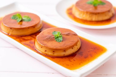 Ev yapımı karamel kremalı puding ahşap arka plan üzerinde