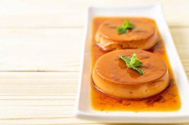 Ev yapımı karamel kremalı puding ahşap arka plan üzerinde