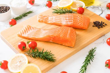 Limon domates Biberiye Biber ve tuz ahşap tahta üzerinde Çiğ somon fileto