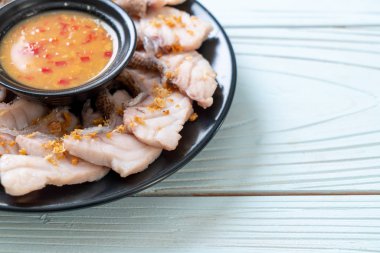 Soslu ve sebzeli haşlanmış balık sosu.