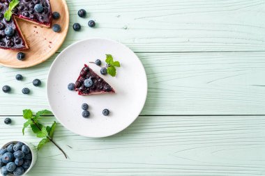 Ahşap arka planda ev yapımı yaban mersinli kek.