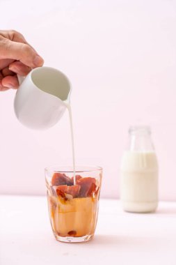 Tay çay buz küpü ile ahşap arka plan üzerinde süt