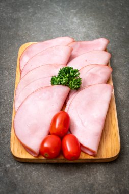 Ahşap tahta üzerinde dilimlenmiş jambon füme