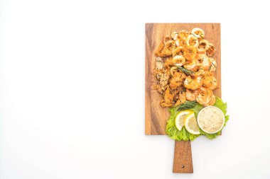 Beyaz arka plan üzerinde izole soslu kızarmış deniz ürünleri (mürekkep, karides, midye)