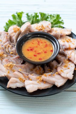 Soslu ve sebzeli haşlanmış balık sosu.