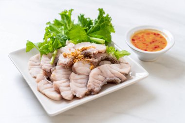 Soslu ve sebzeli haşlanmış balık sosu.