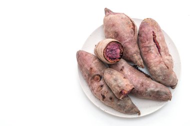 Beyaz arka planda izole edilmiş mor patatesler.