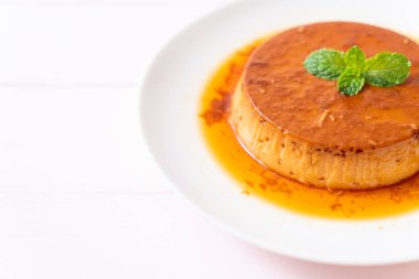 Ev yapımı karamel kremalı puding ahşap arka plan üzerinde