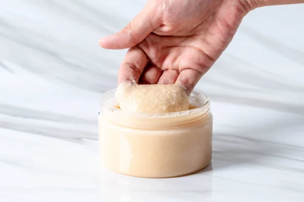 scrub jar with hand for skincare
