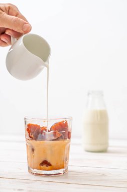 Tay çay buz küpü ile ahşap arka plan üzerinde süt