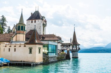 Thun Gölü arka planda İsviçre ile Oberhofen kalesinde güzel mimari