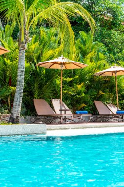 Şemsiye ve sandalye yüzme havuzunda otel ve tatil - tatil tatil kavramı çevresinde