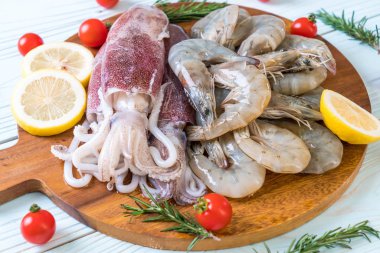 taze deniz ürünleri ham (karides, mürekkep) malzemelerle ahşap tahta üzerinde