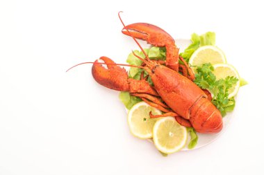 Beyaz arka planda taze haşlanmış sebze ve limonlu ıstakoz.