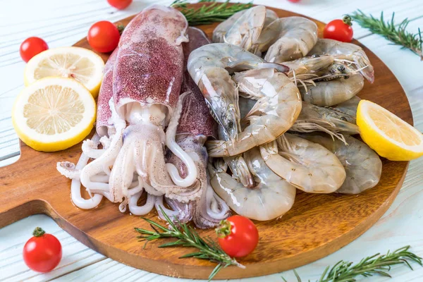 taze deniz ürünleri ham (karides, mürekkep) malzemelerle ahşap tahta üzerinde