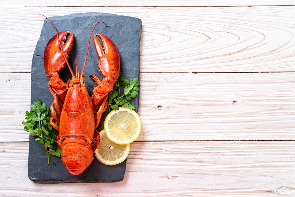 red lobster with vegetable and lemon on black slate plate