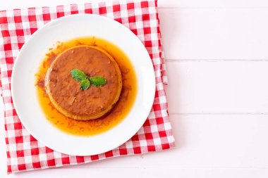 Ev yapımı karamel kremalı puding ahşap arka plan üzerinde