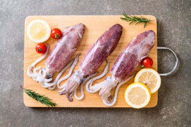 taze ahtapot veya mürekkep malzemelerle ahşap tahta üzerinde ham