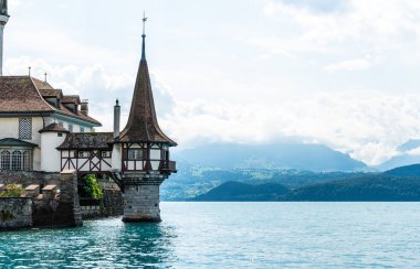 Thun Gölü arka planda İsviçre ile Oberhofen kalesinde güzel mimari