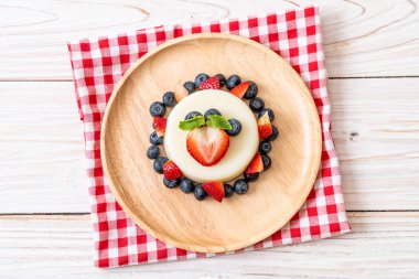 yoğurt puding plaka üzerinde bir yaban mersini ve taze çilek ile