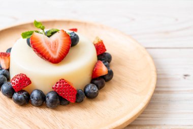 yoğurt puding plaka üzerinde bir yaban mersini ve taze çilek ile
