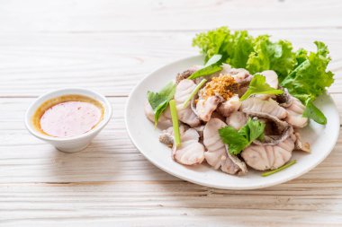 Soslu ve sebzeli haşlanmış balık sosu.