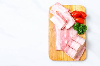 Ahşap tahta üzerinde çiğ domuz pastırma dilimlenmiş