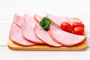 Ahşap tahta üzerinde dilimlenmiş jambon füme