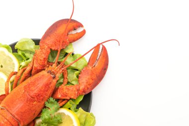 Beyaz arka planda taze haşlanmış sebze ve limonlu ıstakoz.