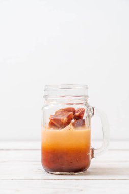 Tay çay buz küpü ile ahşap arka plan üzerinde süt