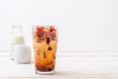 Tay çay buz küpü ile ahşap arka plan üzerinde süt
