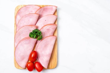 Ahşap tahta üzerinde dilimlenmiş jambon füme
