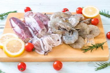 taze deniz ürünleri ham (karides, mürekkep) malzemelerle ahşap tahta üzerinde