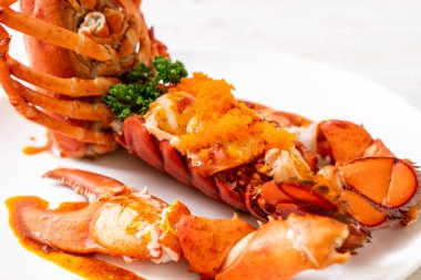 Soslu ıstakoz kuyruklu biftek ve beyaz arka planda karides yumurtaları.