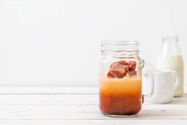 Tay çay buz küpü ile ahşap arka plan üzerinde süt