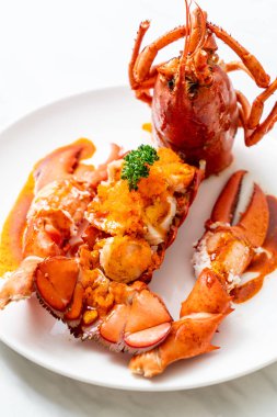 Soslu ıstakoz kuyruklu biftek ve beyaz arka planda karides yumurtaları.