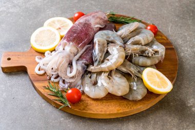 taze deniz ürünleri ham (karides, mürekkep) malzemelerle ahşap tahta üzerinde