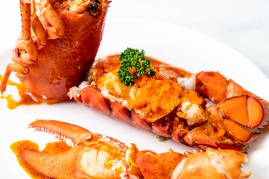 Soslu ıstakoz kuyruklu biftek ve beyaz arka planda karides yumurtaları.