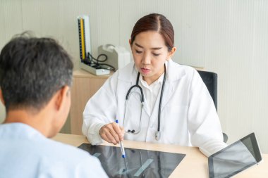 Asyalı kadın doktor ve hasta masada - seçici otururken bir şey tartışırken noktaya odaklama