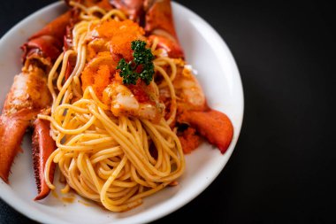 Beyaz tabakta karides yumurtalı ıstakoz spagettisi.