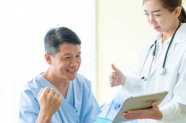 Asya kıdemli hasta hastane yatak kadın doktor - seçici odak noktası ile tartışırken.