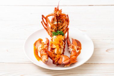 Soslu ıstakoz kuyruklu biftek ve beyaz arka planda karides yumurtaları.