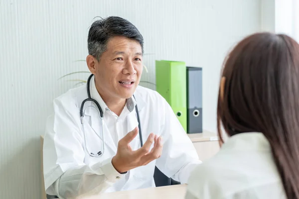 Ázsiai Vezető Orvos Beteg Beszélünk Valamit Miközben Asztalnál — Stock Fotó