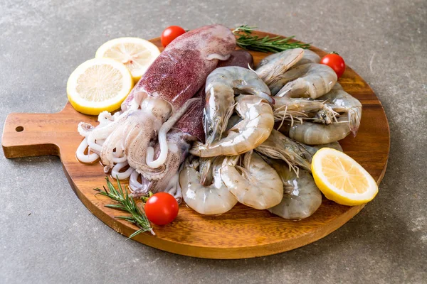 taze deniz ürünleri ham (karides, mürekkep) malzemelerle ahşap tahta üzerinde