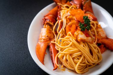 Beyaz tabakta karides yumurtalı ıstakoz spagettisi.