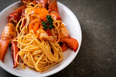 Beyaz tabakta karides yumurtalı ıstakoz spagettisi.