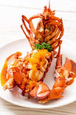 Soslu ıstakoz kuyruklu biftek ve beyaz arka planda karides yumurtaları.