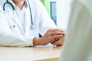 Kıdemli doktor kadın hastasını güven verici el