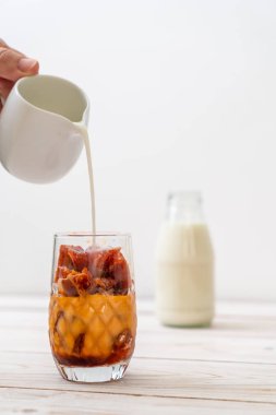 Tay çay buz küpü ile ahşap arka plan üzerinde süt
