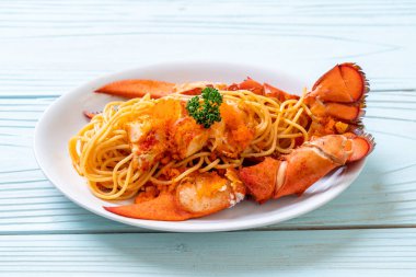 Beyaz tabakta karides yumurtalı ıstakoz spagettisi.